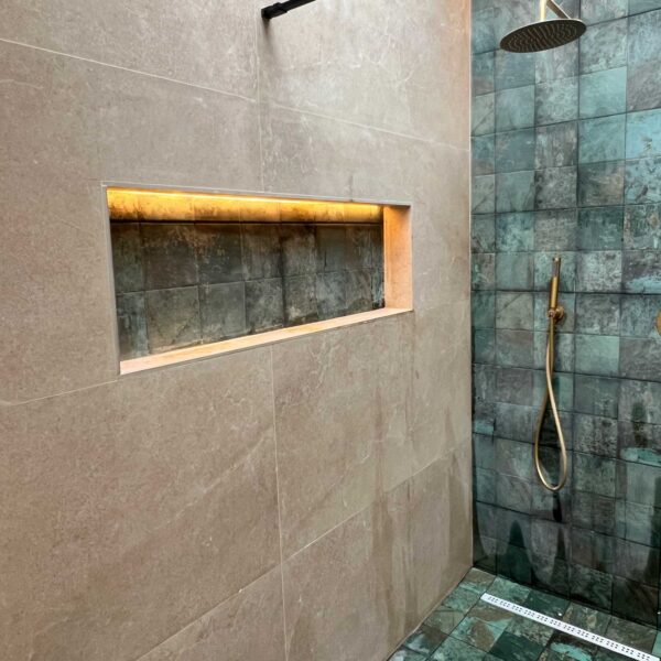 Baño reformado con mueble suspendido, lavabo de piedra y sanitario blanco