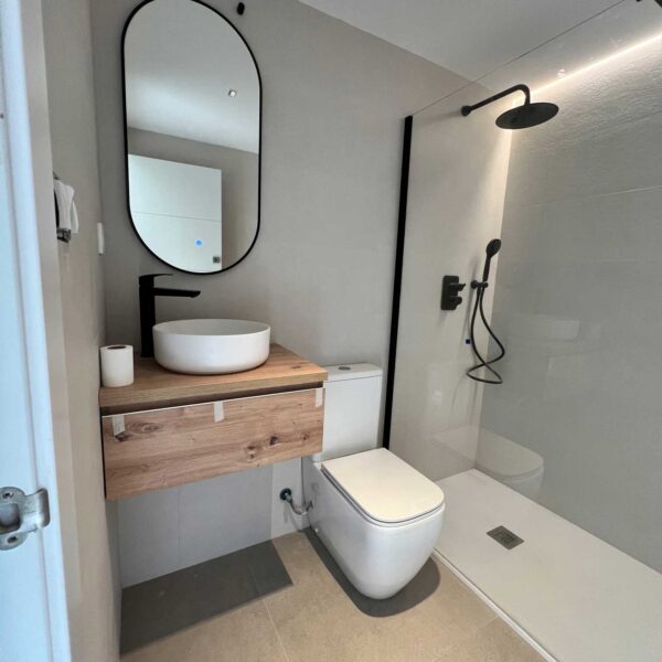 Ducha con mampara de cristal, rociador negro y luz LED integrada en pared