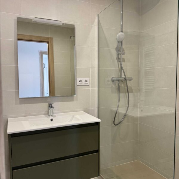 Baño reformado con mueble suspendido y sanitario blanco